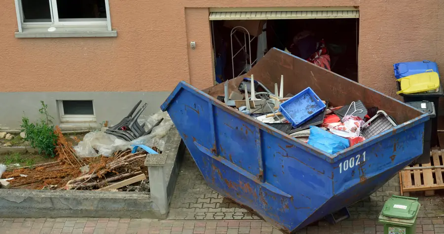Container mit Sperrmüll vor einem Haus