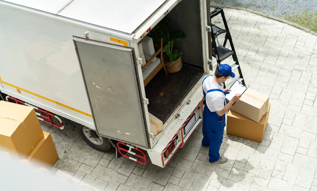 Umzugshelfer mit Klemmbrett am geöffneten LKW